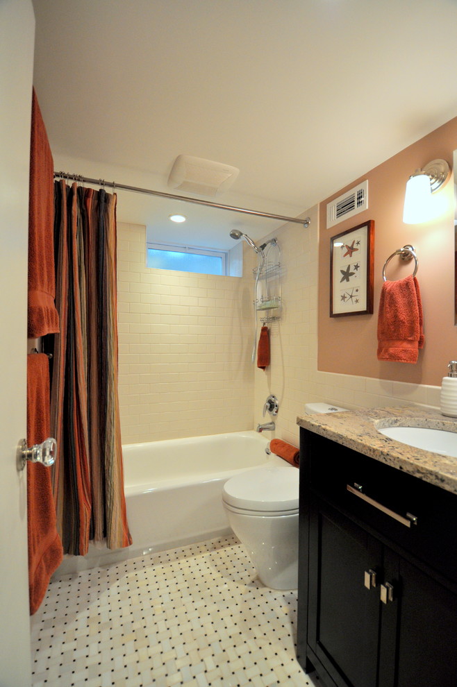Foto de cuarto de baño tradicional renovado con lavabo bajoencimera, armarios con paneles lisos, puertas de armario de madera en tonos medios, encimera de granito y sanitario de dos piezas
