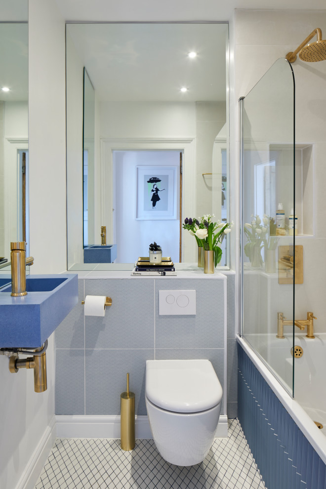 Ejemplo de cuarto de baño actual con bañera empotrada, combinación de ducha y bañera, sanitario de pared, baldosas y/o azulejos azules, baldosas y/o azulejos de porcelana, paredes blancas, aseo y ducha, lavabo suspendido y suelo multicolor