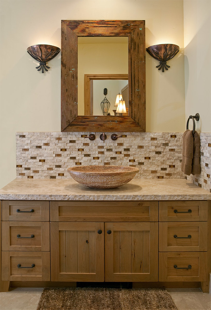 Cette photo montre une grande salle de bain montagne en bois clair avec une vasque, un carrelage beige, un carrelage de pierre, un mur beige, un sol en carrelage de céramique, un placard à porte affleurante et un plan de toilette en calcaire.