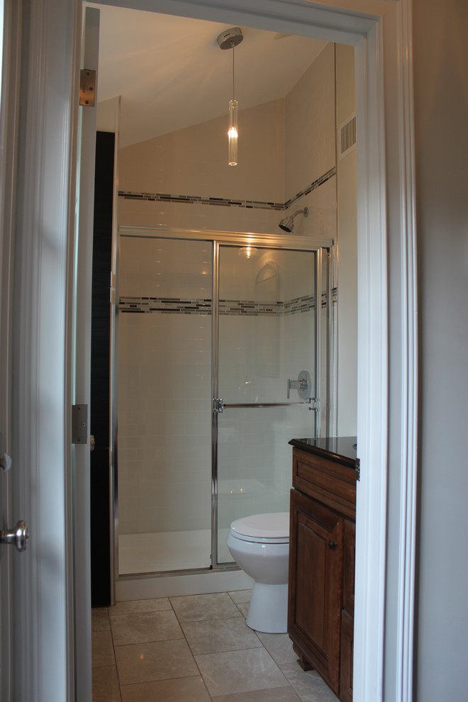 Photo of a small bohemian bathroom in Philadelphia with a submerged sink, raised-panel cabinets, medium wood cabinets, granite worktops, an alcove shower, a one-piece toilet, metro tiles, beige walls and marble flooring.