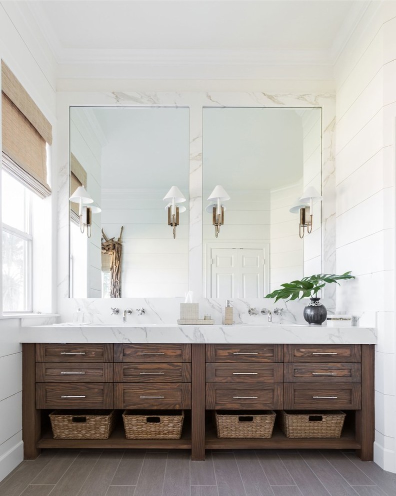 Cette image montre une salle de bain principale en bois foncé avec un mur blanc, un lavabo encastré, un sol marron, un plan de toilette blanc, du carrelage en marbre et un placard à porte shaker.