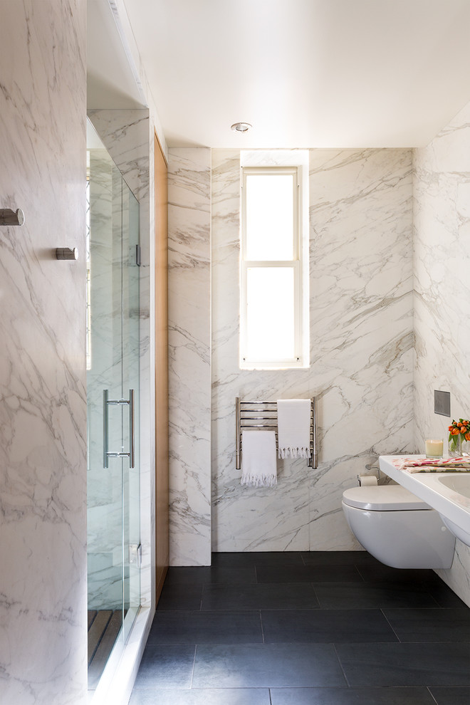 На фото: ванная комната среднего размера в стиле модернизм с инсталляцией, белыми стенами, душем в нише, полом из сланца, подвесной раковиной и столешницей из искусственного кварца с