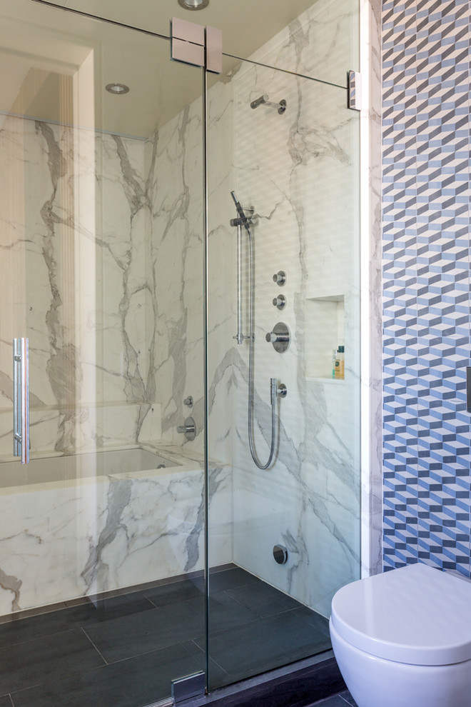 Modelo de cuarto de baño moderno de tamaño medio con ducha empotrada, sanitario de pared, paredes blancas, suelo de pizarra, lavabo suspendido y encimera de cuarzo compacto