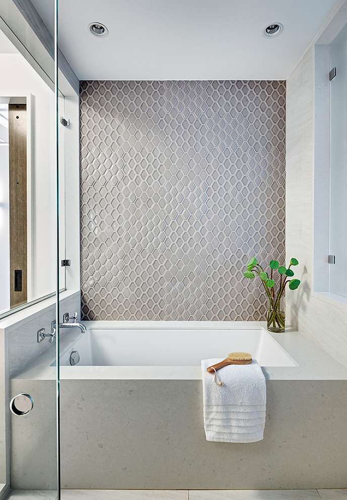 Cette image montre une salle de bain urbaine avec un combiné douche/baignoire, un mur gris, un sol beige et une cabine de douche à porte battante.