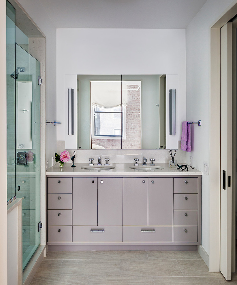 Industriell inredning av ett grå grått badrum med dusch, med vita väggar, dusch med gångjärnsdörr, beiget golv, släta luckor, grå skåp, en dusch i en alkov och ett undermonterad handfat