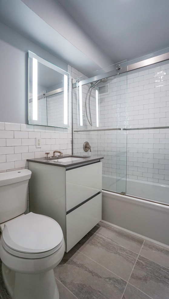 Kleines Modernes Badezimmer mit Einbaubadewanne, Duschbadewanne, weißen Fliesen, Keramikfliesen, grauer Wandfarbe, Keramikboden, Unterbauwaschbecken, grauem Boden und Schiebetür-Duschabtrennung in New York