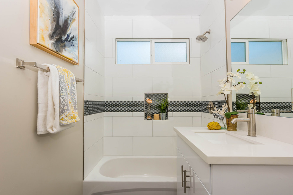 Coastal shower room bathroom in Los Angeles with flat-panel cabinets, white cabinets, an alcove bath, a shower/bath combination, white tiles, beige walls, a submerged sink and white worktops.