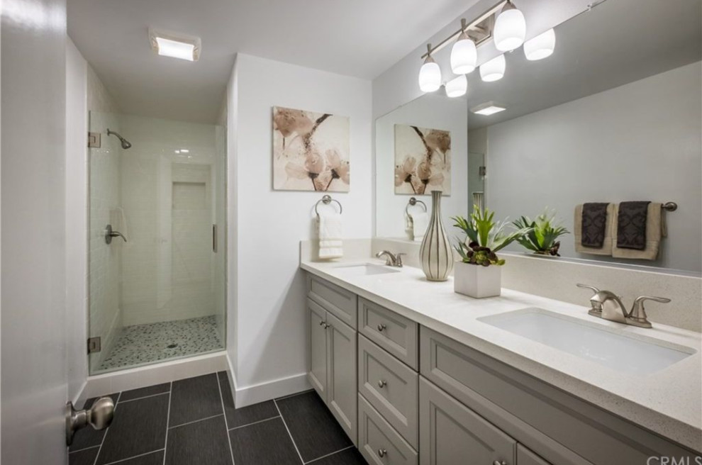 Inredning av ett klassiskt mellanstort beige beige badrum med dusch, med luckor med infälld panel, grå skåp, en dusch i en alkov, vit kakel, tunnelbanekakel, vita väggar, svart golv och dusch med gångjärnsdörr