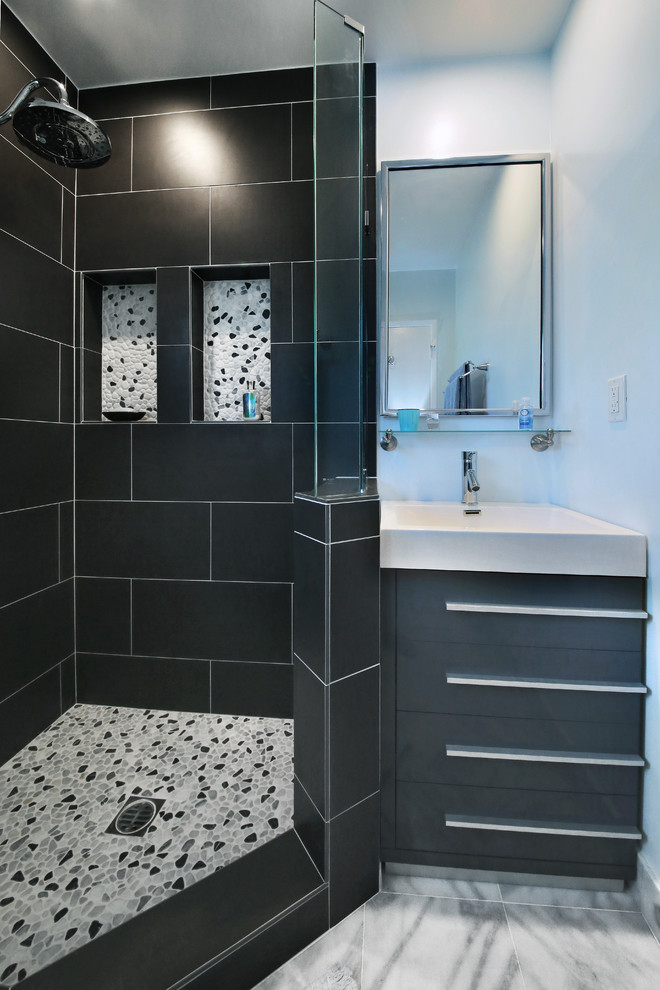 Bild på ett litet industriellt en-suite badrum, med ett konsol handfat, luckor med infälld panel, grå skåp, bänkskiva i akrylsten, en hörndusch, en toalettstol med separat cisternkåpa, grå kakel, porslinskakel, blå väggar och marmorgolv