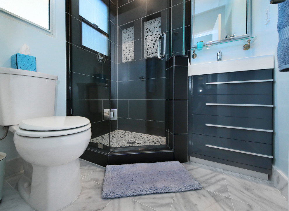 Exempel på ett litet modernt en-suite badrum, med luckor med infälld panel, grå skåp, ett konsol handfat, bänkskiva i akrylsten, en hörndusch, en toalettstol med separat cisternkåpa, grå kakel, porslinskakel, blå väggar och marmorgolv