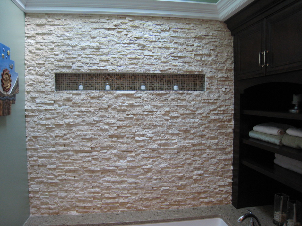 Diseño de sauna tradicional, grande, con lavabo bajoencimera, armarios con paneles empotrados, puertas de armario de madera en tonos medios, encimera de cuarcita, bañera encastrada sin remate, sanitario de dos piezas, baldosas y/o azulejos beige, baldosas y/o azulejos de piedra, paredes verdes y suelo de travertino