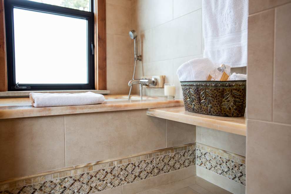 Cette image montre une grande salle de bain principale chalet en bois brun avec une douche double, un carrelage beige, un sol en carrelage de céramique, un plan de toilette en granite, une cabine de douche à porte battante, un plan de toilette beige et meuble double vasque.