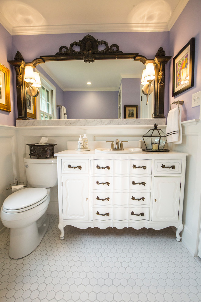 Foto på ett litet eklektiskt badrum, med möbel-liknande, vita skåp, ett badkar i en alkov, en toalettstol med separat cisternkåpa, lila väggar, klinkergolv i keramik, ett nedsänkt handfat, bänkskiva i onyx och vitt golv
