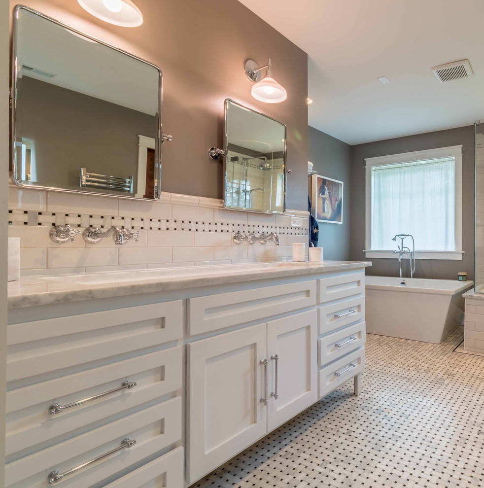 Medium sized traditional grey and white ensuite bathroom in Chicago with shaker cabinets, white cabinets, a freestanding bath, a two-piece toilet, black and white tiles, metro tiles, grey walls, marble flooring, a submerged sink, marble worktops, white floors, a hinged door, white worktops, an alcove shower, a shower bench, double sinks, a freestanding vanity unit, a wallpapered ceiling and wallpapered walls.