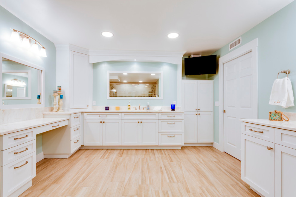 Design ideas for a large traditional ensuite bathroom in Tampa with shaker cabinets, white cabinets, an alcove shower, a two-piece toilet, beige tiles, marble tiles, blue walls, light hardwood flooring, a submerged sink, marble worktops, beige floors and a hinged door.
