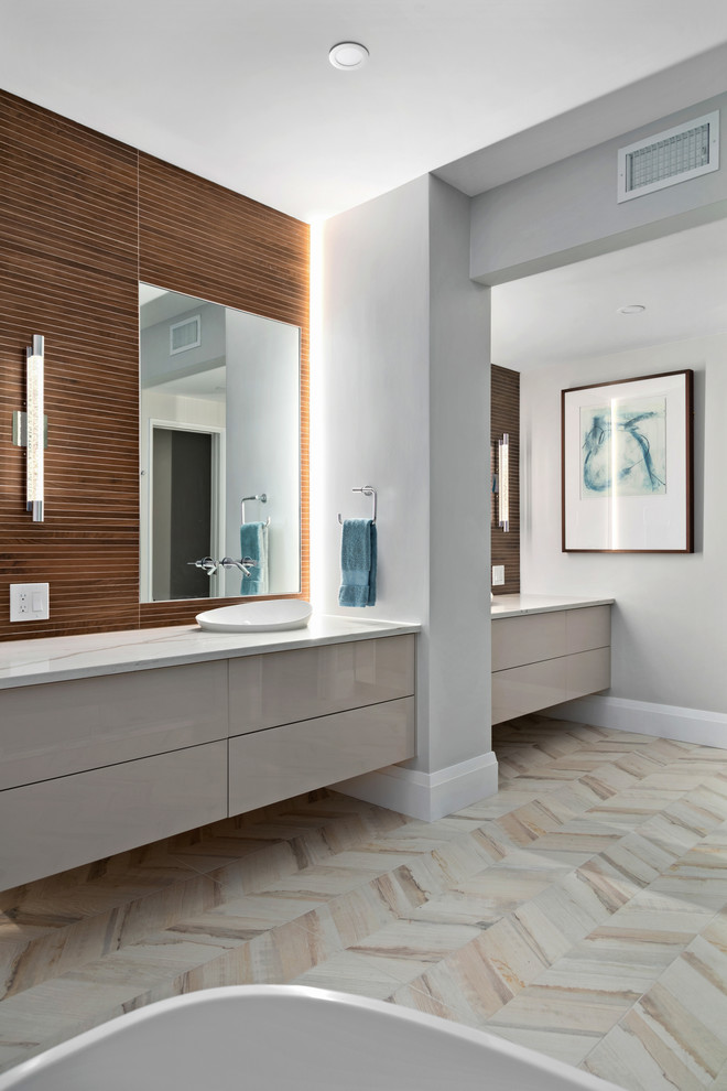 Exempel på ett modernt vit vitt en-suite badrum, med släta luckor, grå skåp, ett fristående badkar, brun kakel, grå väggar, ett fristående handfat och beiget golv