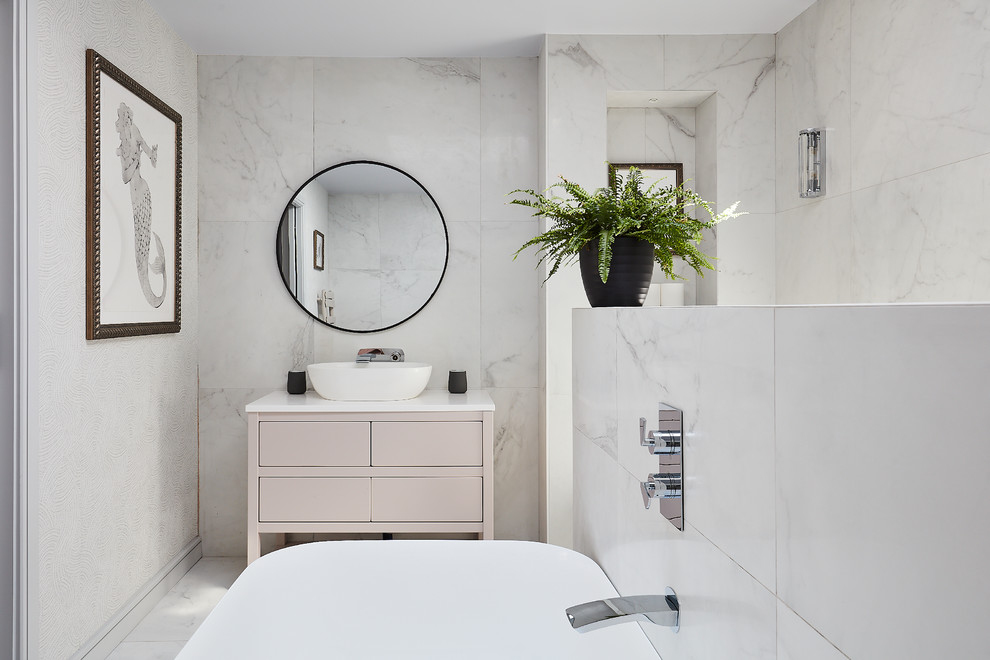 На фото: ванная комната в морском стиле с плоскими фасадами, бежевыми фасадами, отдельно стоящей ванной, белой плиткой, настольной раковиной, белым полом и белой столешницей