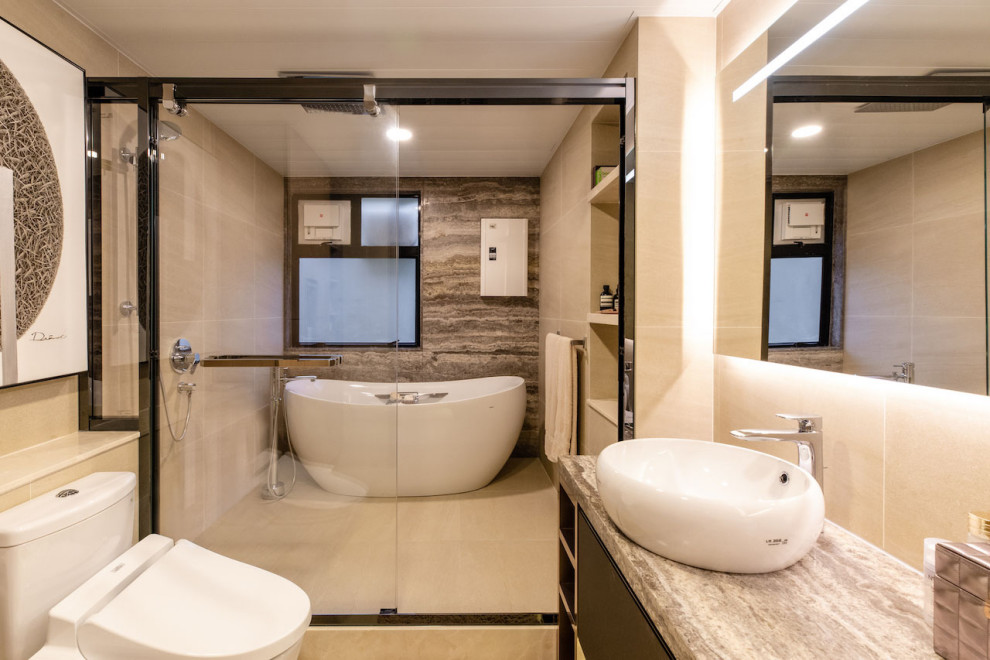 This is an example of a medium sized contemporary ensuite bathroom in Hong Kong with flat-panel cabinets, dark wood cabinets, a freestanding bath, a built-in shower, a one-piece toilet, beige tiles, ceramic tiles, beige walls, ceramic flooring, a vessel sink, marble worktops, beige floors, a sliding door and multi-coloured worktops.