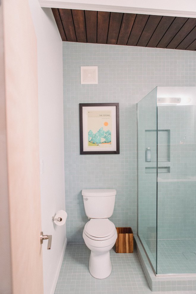 Example of a small mid-century modern master blue tile and ceramic tile ceramic tile and blue floor corner shower design in Grand Rapids with flat-panel cabinets, light wood cabinets, a two-piece toilet, white walls, an integrated sink, quartz countertops, a hinged shower door and white countertops