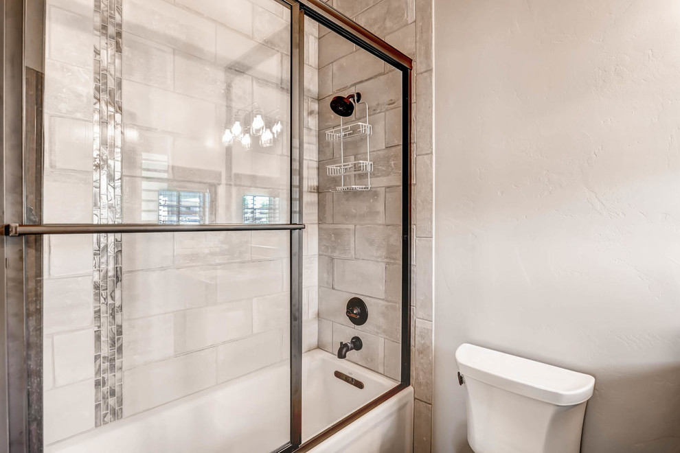 Bild på ett litet rustikt en-suite badrum, med möbel-liknande, svarta skåp, ett platsbyggt badkar, en dusch/badkar-kombination, en toalettstol med hel cisternkåpa, grå kakel, porslinskakel, vita väggar, ett undermonterad handfat, granitbänkskiva, mörkt trägolv, brunt golv och dusch med gångjärnsdörr