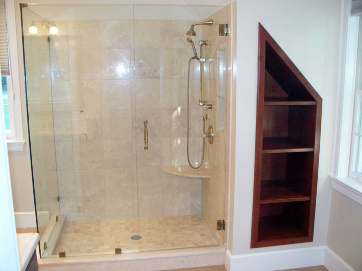 Exempel på ett stort klassiskt en-suite badrum, med ett undermonterad handfat, luckor med profilerade fronter, skåp i mörkt trä, marmorbänkskiva, en dubbeldusch, en toalettstol med hel cisternkåpa, beige kakel, stenkakel, beige väggar och klinkergolv i porslin