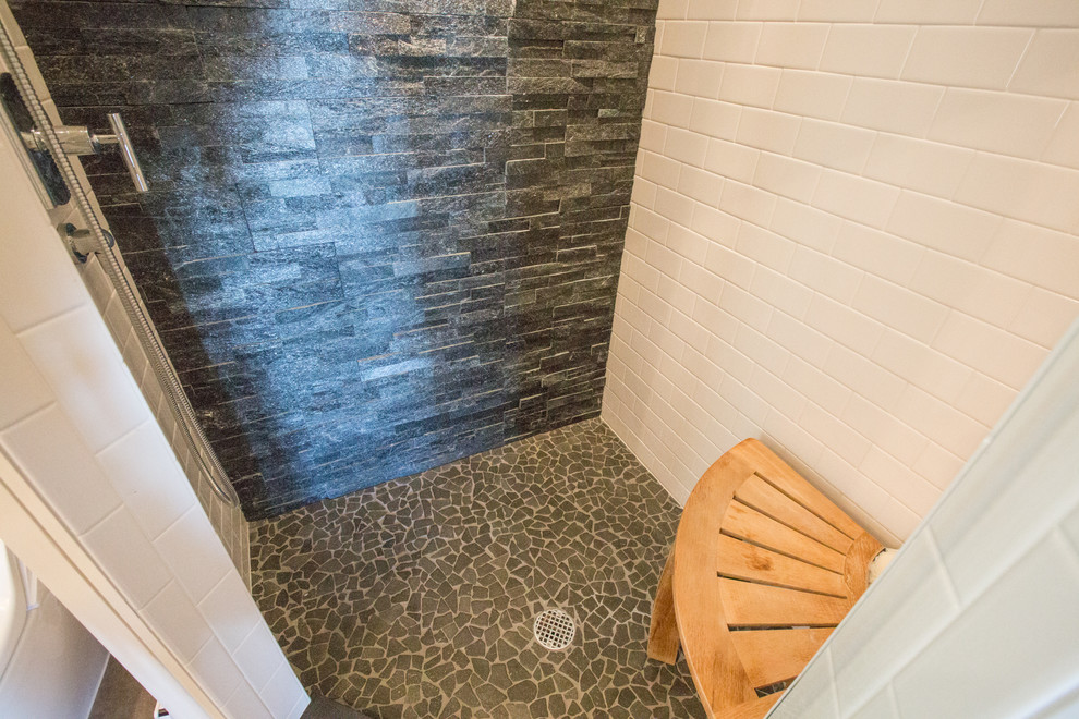 Imagen de cuarto de baño rural de tamaño medio con ducha esquinera, baldosas y/o azulejos grises, baldosas y/o azulejos de piedra, paredes beige y aseo y ducha