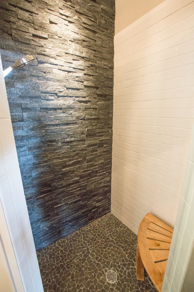 Esempio di una stanza da bagno con doccia rustica di medie dimensioni con doccia ad angolo, piastrelle grigie, piastrelle in pietra e pareti beige