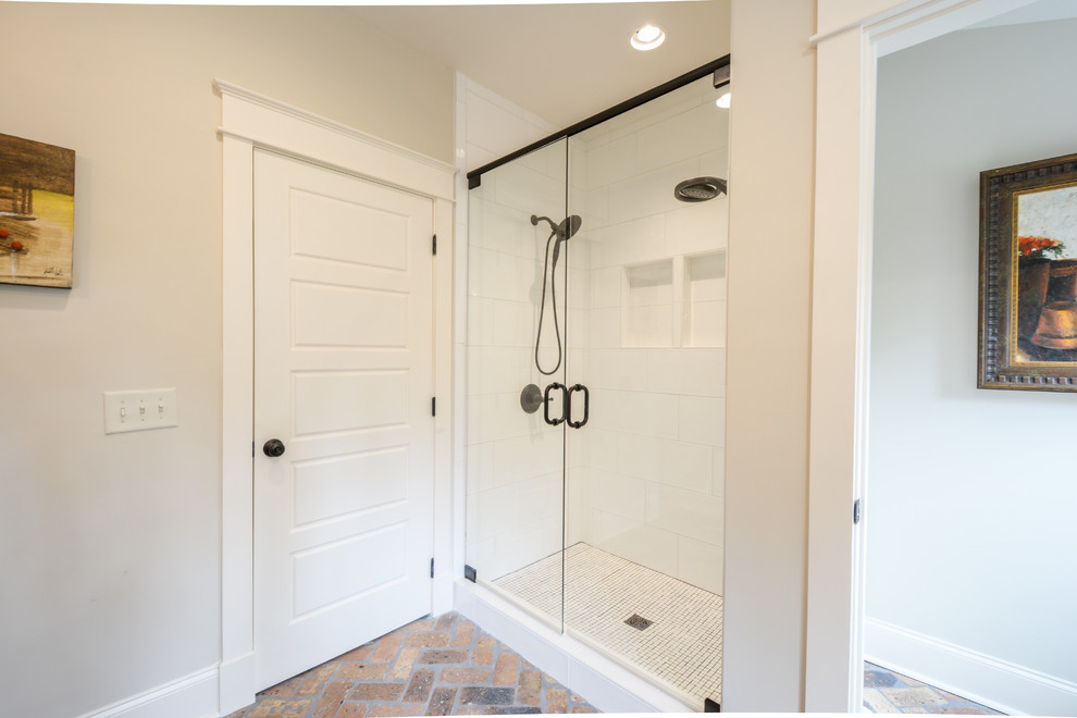 Exempel på ett mellanstort amerikanskt brun brunt en-suite badrum, med öppna hyllor, skåp i slitet trä, vit kakel, tunnelbanekakel, beige väggar, tegelgolv, ett undermonterad handfat, träbänkskiva, flerfärgat golv och dusch med gångjärnsdörr