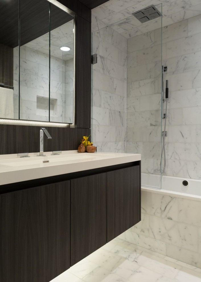 Modern inredning av ett mellanstort badrum för barn, med släta luckor, skåp i mörkt trä, ett badkar i en alkov, en dusch/badkar-kombination, grå kakel, vit kakel, marmorkakel, bruna väggar, marmorgolv, ett undermonterad handfat, bänkskiva i kvarts, vitt golv och med dusch som är öppen