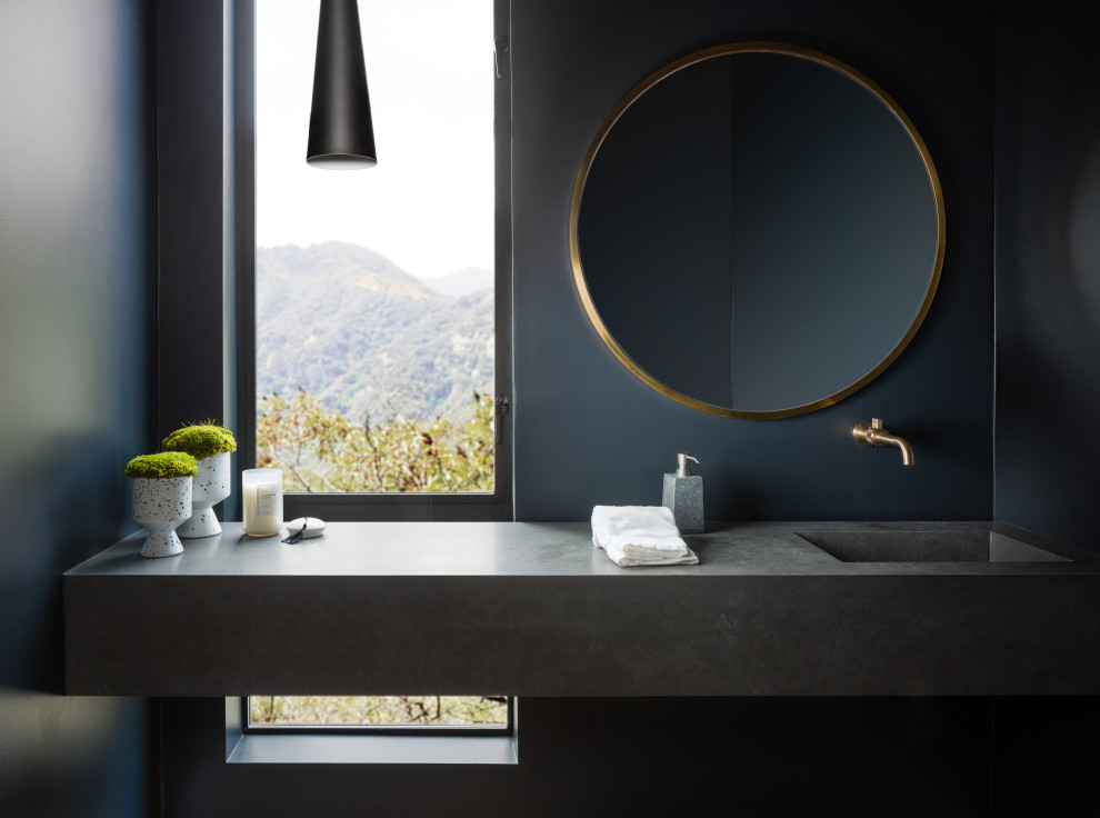 На фото: ванная комната в современном стиле с черными стенами, монолитной раковиной и серой столешницей с