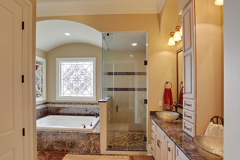 Aménagement d'une grande salle de bain principale classique avec une vasque, une baignoire posée, une douche d'angle, un placard avec porte à panneau surélevé, des portes de placard beiges, un carrelage beige, un carrelage marron, mosaïque, un mur beige, un plan de toilette en marbre et un sol en travertin.