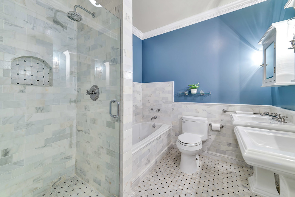 Ispirazione per una stanza da bagno minimalista di medie dimensioni con ante bianche, vasca idromassaggio, piastrelle bianche, piastrelle di marmo, pareti blu, pavimento in marmo e lavabo a colonna