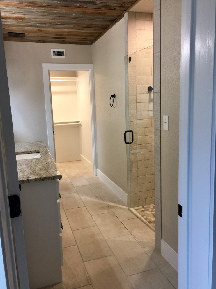 Cette image montre une salle de bain rustique avec WC à poser, un mur beige, carreaux de ciment au sol, un plan de toilette en granite, un sol beige et un plan de toilette multicolore.