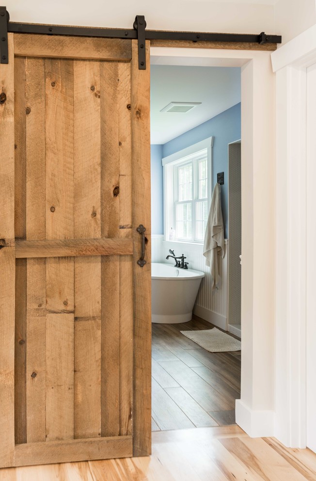 Mittelgroßes Landhausstil Badezimmer En Suite mit freistehender Badewanne, offener Dusche, blauer Wandfarbe, Porzellan-Bodenfliesen, braunem Boden und offener Dusche in Portland Maine