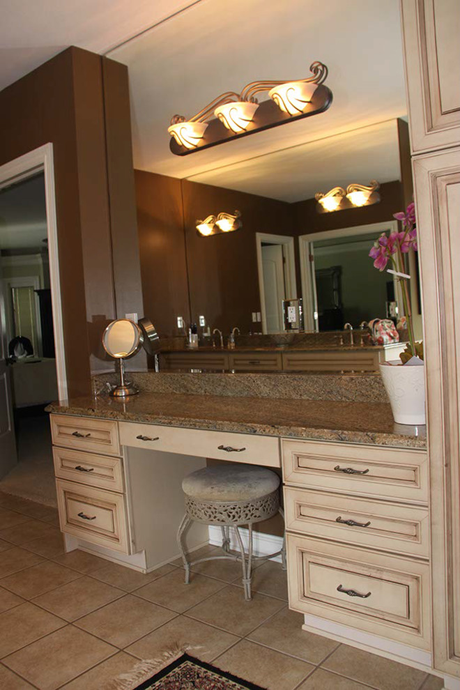 Imagen de cuarto de baño clásico con lavabo bajoencimera, puertas de armario con efecto envejecido, encimera de granito, bañera encastrada sin remate y baldosas y/o azulejos blancos
