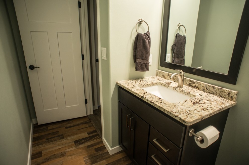 Foto di una piccola stanza da bagno con doccia bohémian con lavabo sottopiano, ante in stile shaker, ante in legno bruno, top in granito, pareti verdi e parquet scuro