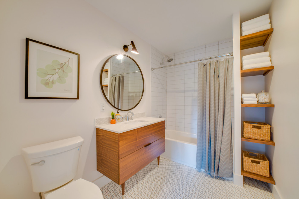 Imagen de cuarto de baño retro con armarios con paneles lisos, puertas de armario de madera oscura y encimera de acrílico