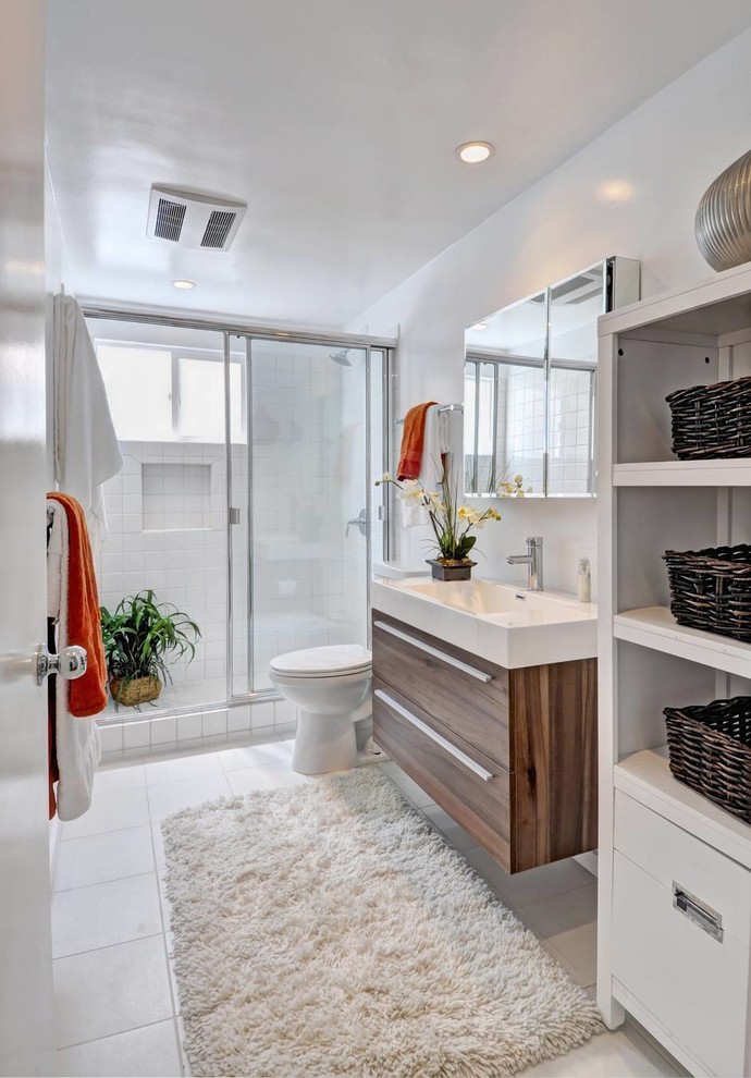 ロサンゼルスにあるコンテンポラリースタイルのおしゃれな浴室 (一体型シンク、フラットパネル扉のキャビネット、中間色木目調キャビネット、アルコーブ型シャワー) の写真