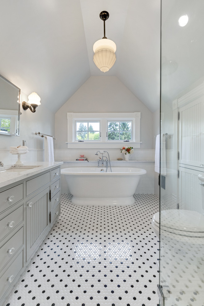 Example of an ornate master white tile and subway tile ceramic tile and multicolored floor freestanding bathtub design in Portland with gray cabinets, a two-piece toilet, gray walls, an undermount sink, quartzite countertops, a hinged shower door and white countertops