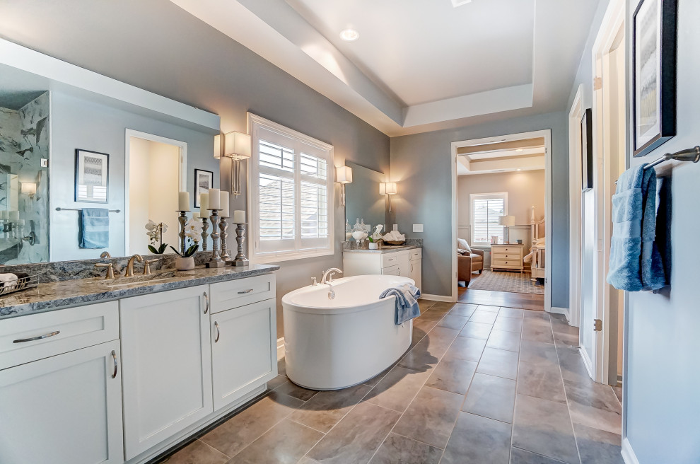 Design ideas for an expansive ensuite bathroom in Charlotte with flat-panel cabinets, white cabinets, a freestanding bath, blue walls, ceramic flooring, engineered stone worktops, an enclosed toilet, double sinks, a built in vanity unit and a coffered ceiling.