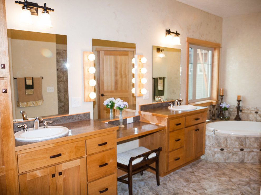 Aménagement d'une salle de bain principale craftsman en bois clair de taille moyenne avec un lavabo posé, un placard avec porte à panneau encastré, un plan de toilette en stratifié, une baignoire d'angle, un carrelage beige, des carreaux de porcelaine et un sol en ardoise.