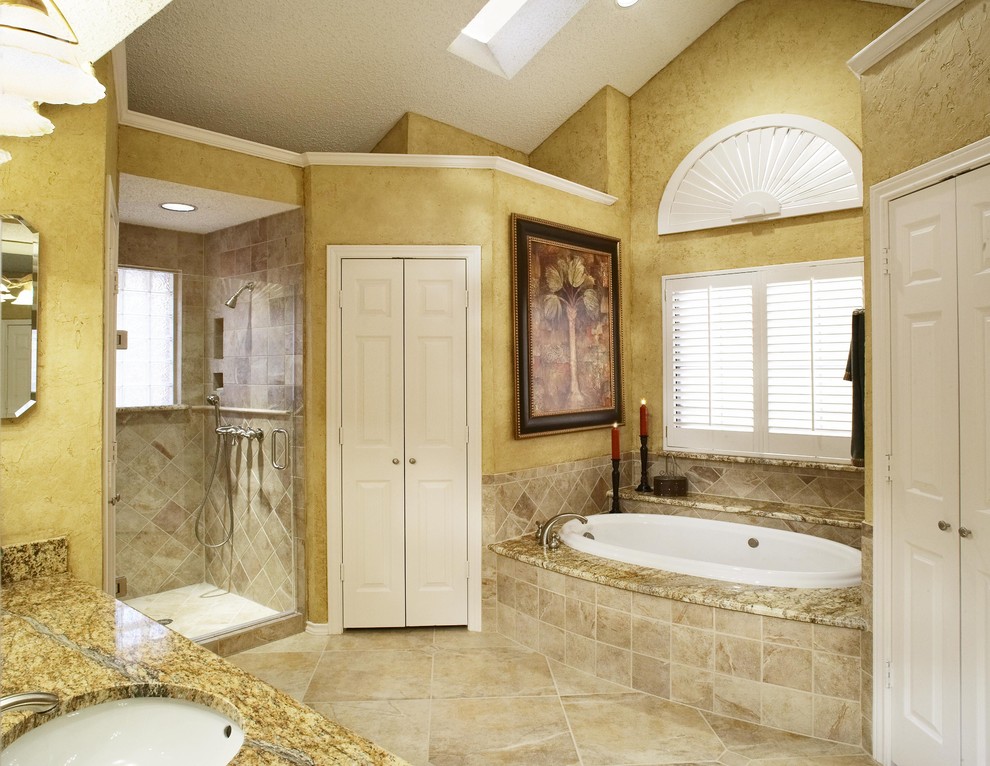 Cette photo montre une salle de bain chic avec une baignoire posée, un plan de toilette en granite et des carreaux de porcelaine.