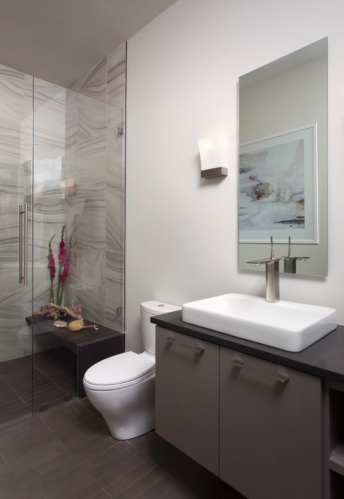Идея дизайна: ванная комната среднего размера в стиле модернизм с плоскими фасадами, серыми фасадами, душем в нише, раздельным унитазом, серой плиткой, белой плиткой, керамической плиткой, белыми стенами, полом из керамической плитки, настольной раковиной, столешницей из искусственного камня, серым полом, душем с распашными дверями и душевой кабиной