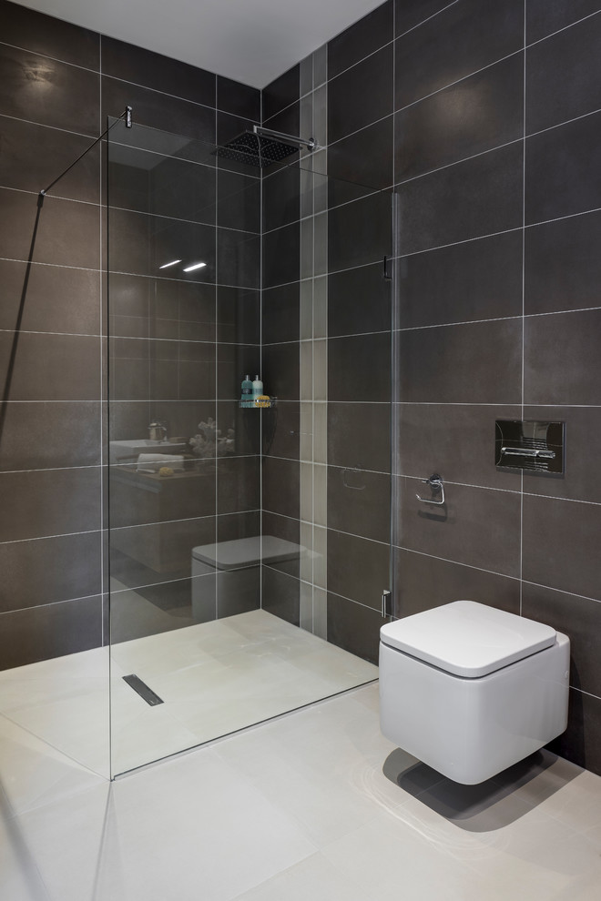 Photo of a medium sized contemporary bathroom in London with flat-panel cabinets, light wood cabinets, porcelain tiles, wooden worktops, a walk-in shower, a wall mounted toilet, brown tiles, brown walls, a wall-mounted sink and white floors.