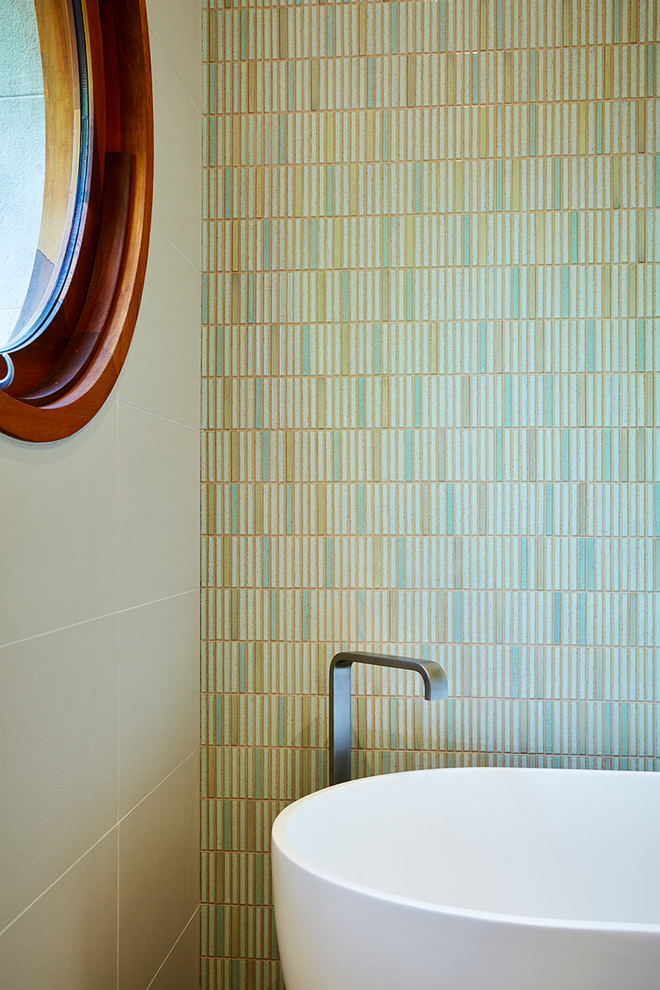 Réalisation d'une salle de bain design avec une baignoire indépendante, une douche d'angle, un carrelage vert, un sol en carrelage de porcelaine et un lavabo intégré.