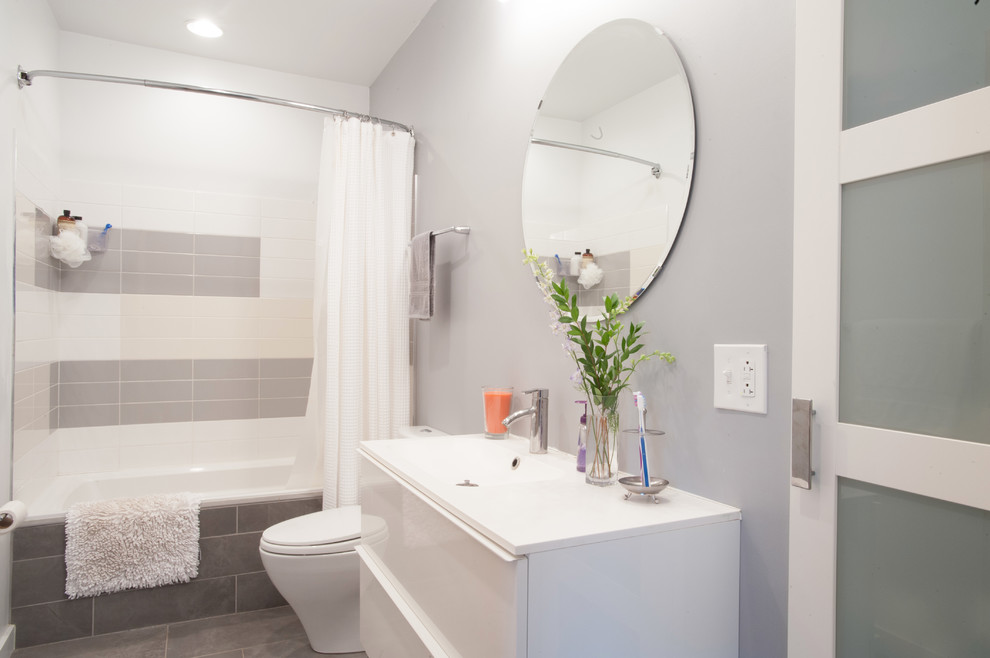 Aménagement d'une salle de bain grise et blanche contemporaine avec un lavabo intégré.