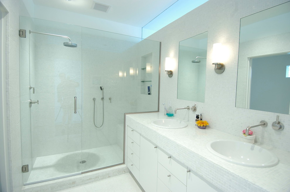 На фото: главная ванная комната среднего размера в стиле модернизм с накладной раковиной, плоскими фасадами, белыми фасадами, столешницей из плитки, душем в нише, белой плиткой, белыми стенами, керамической плиткой, полом из керамической плитки и душем с распашными дверями