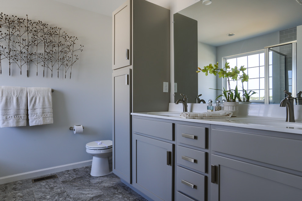 Inspiration for a mid-sized cottage master ceramic tile vinyl floor and multicolored floor corner shower remodel in Other with raised-panel cabinets, gray cabinets, gray walls, an undermount sink, marble countertops and a hinged shower door
