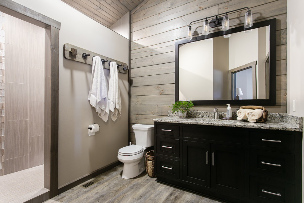 Bild på ett mellanstort rustikt grå grått en-suite badrum, med skåp i shakerstil, svarta skåp, en öppen dusch, en toalettstol med separat cisternkåpa, grå kakel, keramikplattor, grå väggar, mellanmörkt trägolv, ett undermonterad handfat, granitbänkskiva, grått golv och med dusch som är öppen