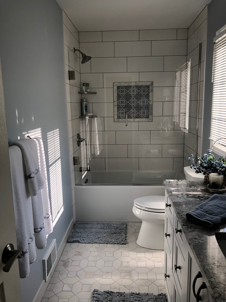 Пример оригинального дизайна: главная ванная комната среднего размера в средиземноморском стиле с фасадами с утопленной филенкой, белыми фасадами, отдельно стоящей ванной, душем над ванной, унитазом-моноблоком, белой плиткой, серыми стенами, полом из керамической плитки, накладной раковиной, столешницей из ламината, серым полом и открытым душем
